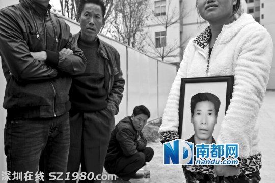 在新塘派出所門口，女兒拿著父親劉先生的遺像為其討公道。 南都記者 黎湛均 攝