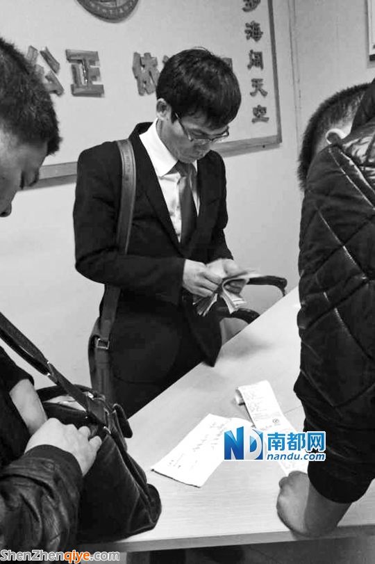 <p> 3月13日，與梁先生的撞車事故調(diào)解獲得賠償后，徐某在大浪交警中隊(duì)調(diào)解室數(shù)錢。</p><p> 南都記者 陳文才翻拍</p>