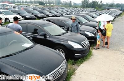 昨日，市民在山東棗莊一家拍賣公司場地上查看待拍賣公車。當(dāng)日，棗莊市103輛公車公開拍賣。新華社記者 馮杰 攝