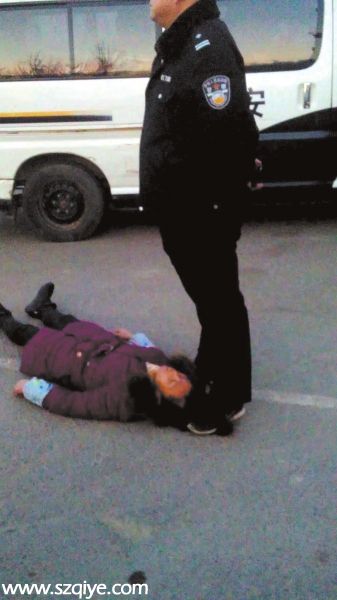 事發(fā)現(xiàn)場(chǎng)一名身穿警服的男子疑似用腳踩著女農(nóng)民 工周秀云的頭發(fā)（12月13日攝）。
