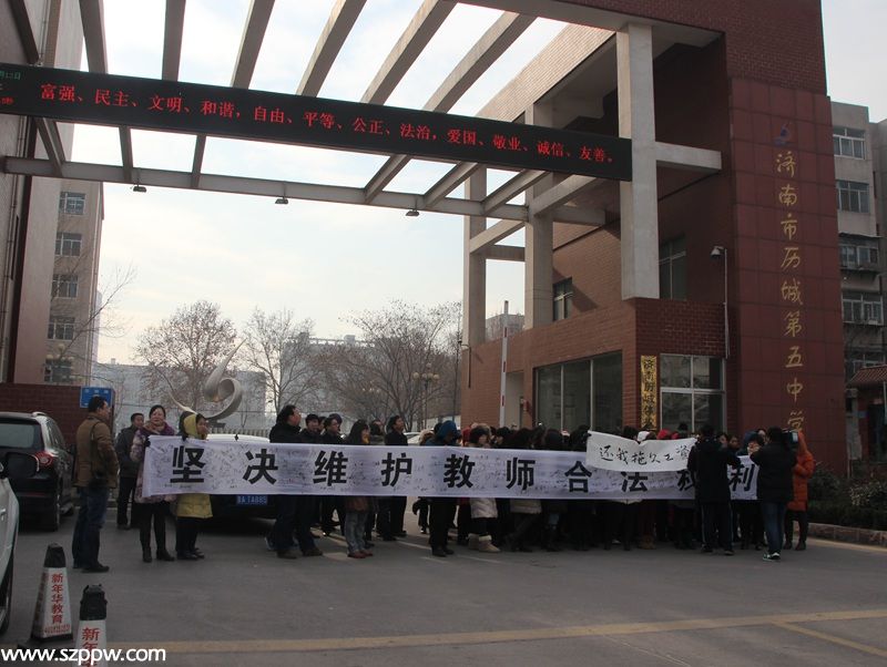 13日上午，濟(jì)南市歷城第五中學(xué)校門口，該校老師打起橫幅維權(quán)。（攝影 宋翠）